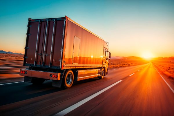 Cargo truck driving on a desert highway from UAE to Saudi Arabia